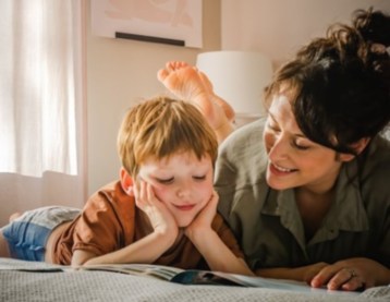 Mom and son lying on the bed reading