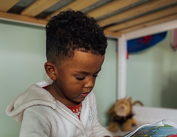 Boy reading a book in bed