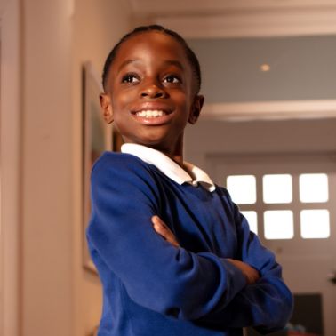 Confident smiling boy standing with his arms crossed