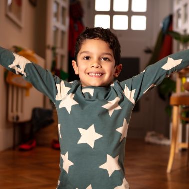 Energised child standing with outstretched arms